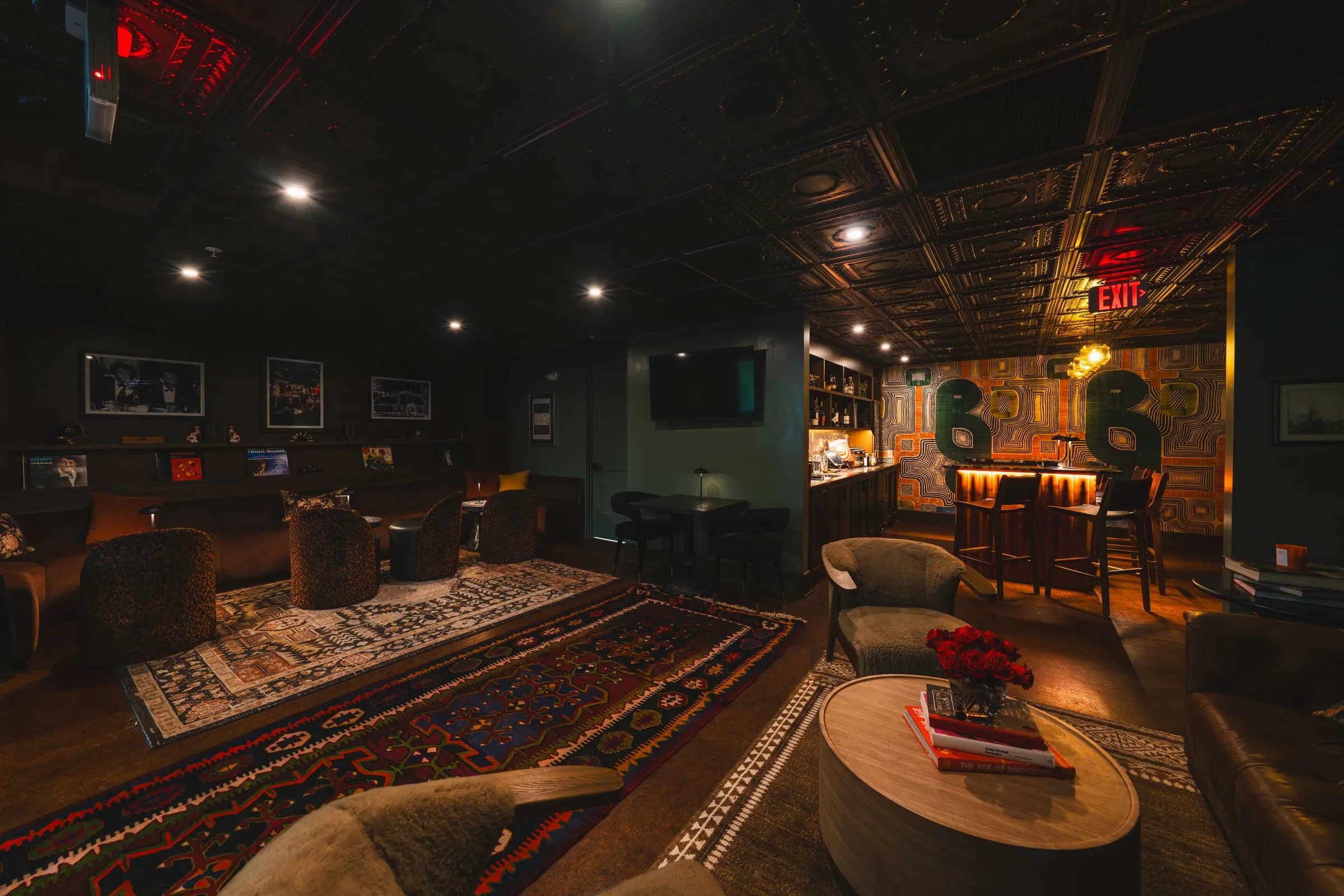 The McCabe Lounge with armchairs and sofas on layered rugs, the bar at the back